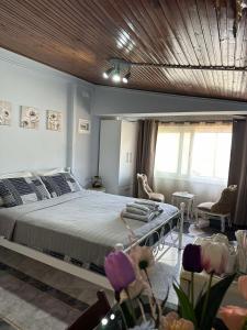 una camera con un grande letto e un soffitto in legno di Με θέα το Κάστρο a Nafpaktos