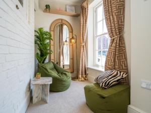 sala de estar con sofá verde y silla en The Loft - a stylish 2-bed in prime central location - Pass the Keys, en Shrewsbury