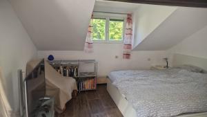 a bedroom with a bed and a book shelf at WOHLFÜHLOASE - Zimmer, Appartment - im Herzen STARNBERGS in Starnberg