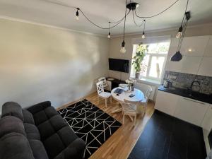 een woonkamer met een bank en een tafel bij Blakus bērnu pilsētiņai un pludmalei in Ventspils