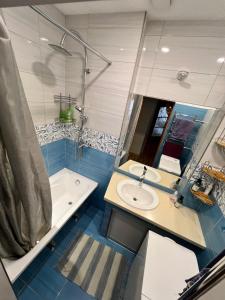 een badkamer met een bad, een wastafel en een douche bij Blakus bērnu pilsētiņai un pludmalei in Ventspils