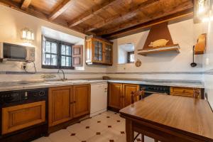 una cucina con mobili in legno e un tavolo in legno di Casa vacacional Dario a Rales