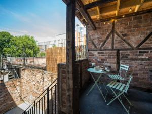 Un patio con una mesa y sillas en una pared de ladrillos. en The Loft - a stylish 2-bed in prime central location - Pass the Keys, en Shrewsbury