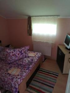 a small bedroom with a bed and a window at Cabana Vanatorului  +17 photos