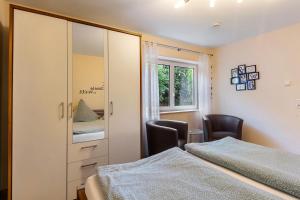 a bedroom with two beds and a cabinet and a window at Ferienwohnung Gretel in Bremm