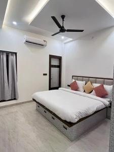 une chambre avec un lit avec un ventilateur de plafond dans l'établissement Sunrise Villa Udaipur, à Udaipur