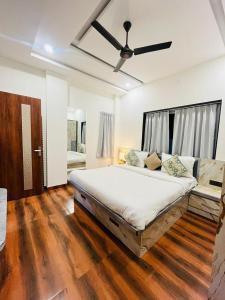 une chambre avec un grand lit avec un ventilateur de plafond dans l'établissement Sunrise Villa Udaipur, à Udaipur