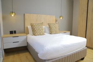 a bedroom with a large white bed with two pillows at The Mandy Guesthouse in Kokstad