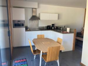 eine Küche mit einem Holztisch und Stühlen in der Unterkunft Petit Gîte 2 - 4 personnes in Le Longeron
