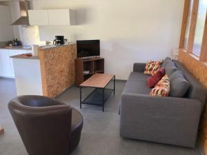 ein Wohnzimmer mit Sofa und Tisch in der Unterkunft Petit Gîte 2 - 4 personnes in Le Longeron
