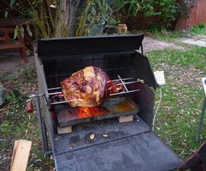 a turkey is cooking in an outdoor grill at Penzion Schola in Noutonice +9 photos