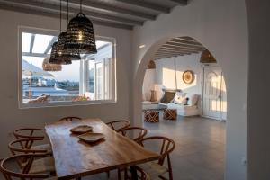 jadalnia z drewnianym stołem i krzesłami w obiekcie Thalia Luxe 4-Bedroom Pool Villa w mieście Mykonos