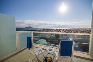 科拉雷侯Hotel Boutique TAO Caleta Mar的阳台配有两把椅子,享有海滩美景