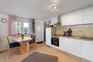 a kitchen with white cabinets and a small table with a table at Appartement Sonnenschein in Berghausen +19 photos
