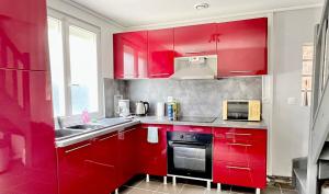 a red kitchen with a sink and a microwave at Maisonnette Villeneuve d Ascq in Villeneuve d'Ascq