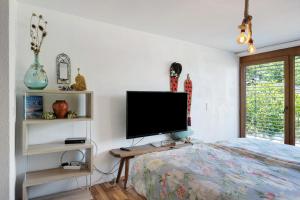 a bedroom with a bed and a flat screen tv at Almschlössle in Gottmadingen
