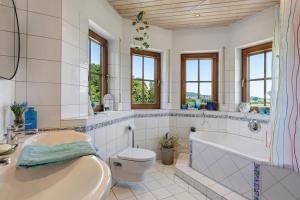 a bathroom with a tub and a toilet and a sink at Almschlössle in Gottmadingen +26 photos