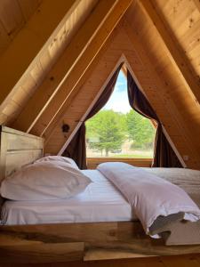 a bed in a loft with a window at Gorska Dolina in Ivanova Korita