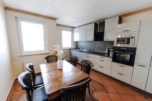 a kitchen with a wooden table and a kitchen with white cabinets at Apartment Josephine in Lübeck