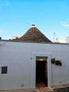 a white building with a roof with a doorway at Spica sul Trullo in Alberobello