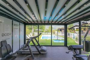 a gym with a view of a swimming pool at Novotel Grenoble Nord Voreppe in Voreppe
