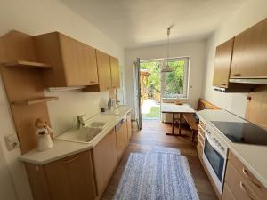 kuchnia z drewnianymi szafkami i dużym oknem w obiekcie Ferienwohnung Tagwerkerstrasse Innenstadt w mieście Gmunden