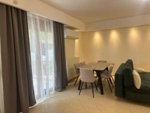 a dining room with a table and chairs and a couch at Advance Real Estate 1 in Alexandroupoli