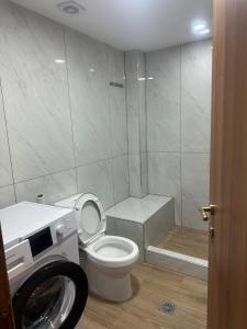 a bathroom with a toilet and a washing machine at Advance Real Estate OE in Alexandroupoli