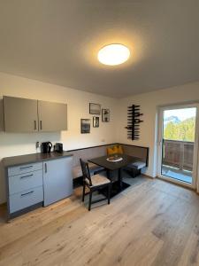 a kitchen with a table and a dining room at Kaiserblick Apartments in Oberau +13 photos