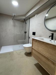a bathroom with a sink and a toilet and a mirror at Apartamentos El Puerto Ayamonte in Ayamonte +2 photos