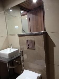 a bathroom with a sink and a mirror at Kiwi Inn Hotel, Ujjain in Ujjain
