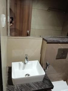 a bathroom with a white sink and a mirror at Kiwi Inn Hotel, Ujjain in Ujjain +9 photos