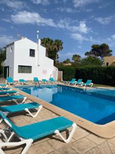 a swimming pool with lounge chairs and a building at M&B Blue Beach in Son Xoriguer