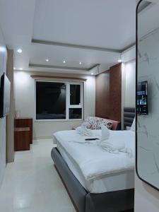 a bedroom with a large bed and a television at Kiwi Inn Hotel, Ujjain in Ujjain