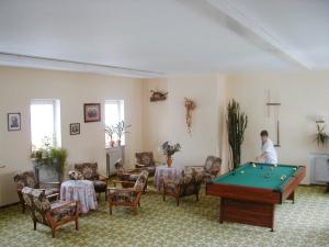 a man standing in a room with a pool table at Pension Eichschmid / Röll´n Biergarten in Bad Gögging