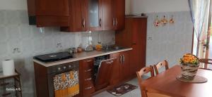 a kitchen with wooden cabinets and a table and a stove at La casa della nonna in Perito