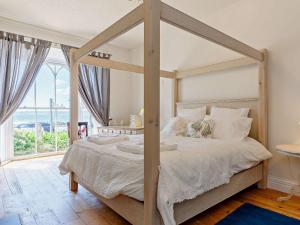 1 dormitorio con cama con dosel y ventana grande en 2 Bed in Marazion 82154, en Marazion