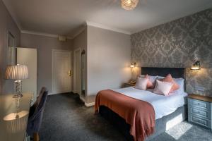 a bedroom with a large bed with pink pillows at Castle Arch Hotel in Trim