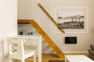 a living room with a staircase and a white table and chair at Lisianthus Apartments in Budapest