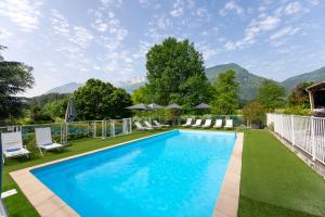 a swimming pool in the yard of a house at Novotel Grenoble Nord Voreppe in Voreppe
