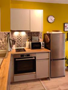 a kitchen with a refrigerator and a microwave at Kalina Apartment Kazanlak in Kazanlŭk