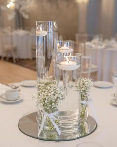 a glass vase with candles and flowers on a table at Castle Arch Hotel in Trim