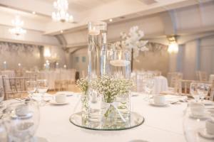 a table with glasses and a vase of flowers on it at Castle Arch Hotel in Trim