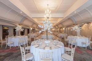 a banquet hall with white tables and chairs and chandeliers at Castle Arch Hotel in Trim