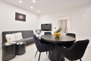 a living room with a table and chairs and a couch at Cataleya Apartments Makarska in Makarska