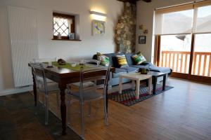 a living room with a table and a blue couch at Albergo Diffuso Zoncolan in Ovaro