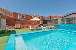 una piscina sul tetto di un edificio con sedie e ombrellone di Casa La Coqueta a Santa Cruz de Tenerife