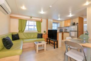 un soggiorno con un divano verde e una cucina di Casa La Coqueta a Santa Cruz de Tenerife