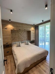 a bedroom with a large bed with a wooden wall at VIP Anvers Villa 50 in Elenite