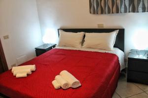 Un dormitorio con una cama roja con dos toallas encima. en La Casetta, en Cefalú